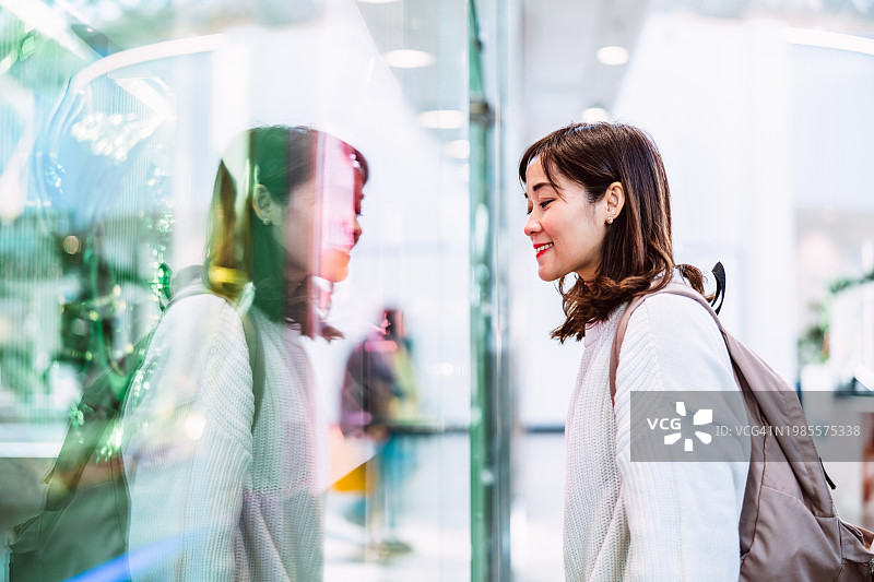亚洲女性在商场看商店橱窗图片素材