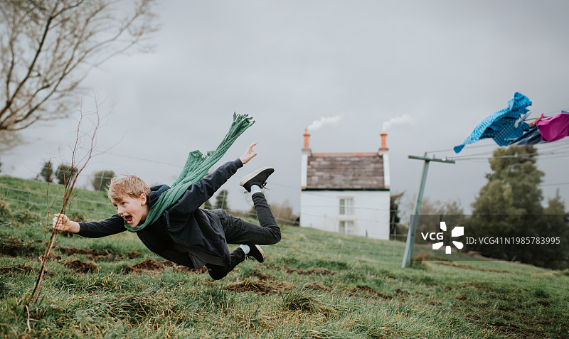 有趣的超现实小男孩被风吹走图片素材
