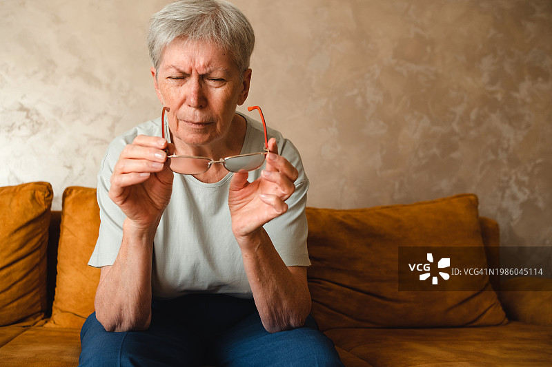 老年人视力问题：老年妇女戴眼镜时斜视图片素材