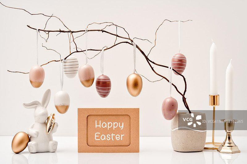 柔和金色复活节彩蛋、树枝与陶瓷复活节兔子图片素材