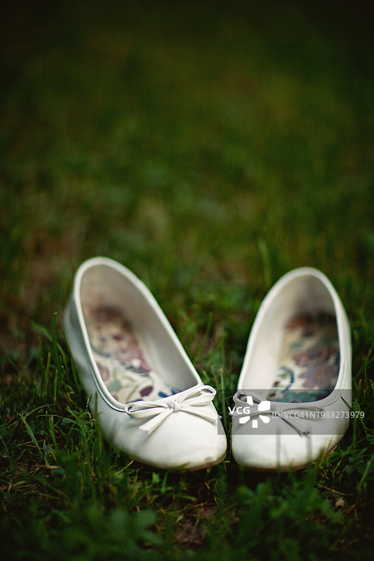 草地上的白色平底女鞋图片素材