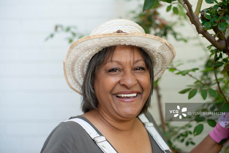 中年妇女在后院园艺，享受绿色爱好图片素材