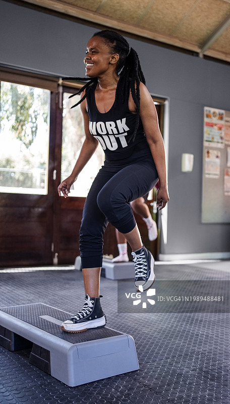 在健身房做有氧运动的快乐年轻非洲女性图片素材