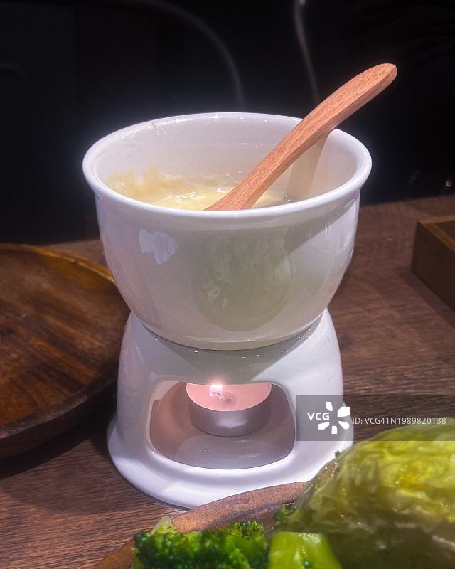 蜡烛加热的奶酪火锅，带来舒适的用餐体验图片素材