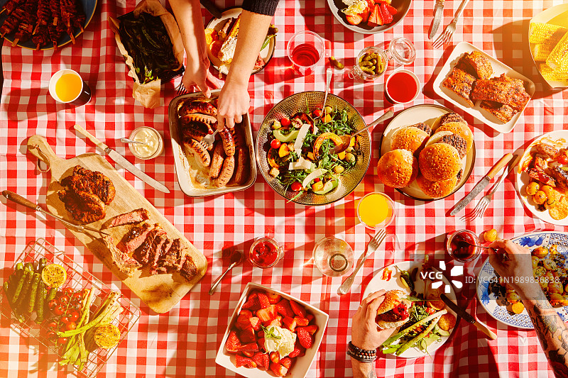 野餐时人们手中的快餐俯视图：包含烧烤，休闲美食，营养健康。提供自助餐或夏季餐厅的用餐和烹饪体验图片素材