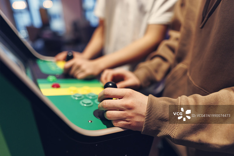 青少年玩复古街机视频游戏特写图片素材