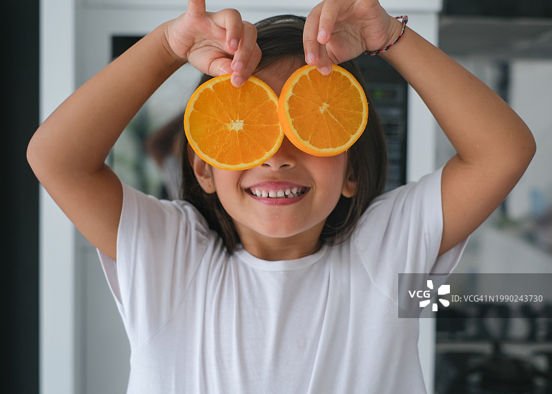 玩橘子片的顽皮小女孩图片素材