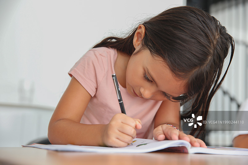 在家教育：小女孩独自做作业和学习图片素材