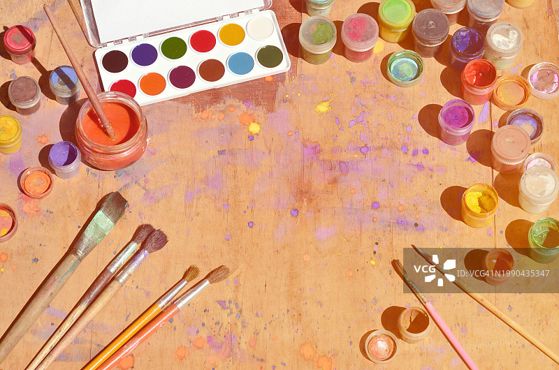 桌子上彩色颜料和画笔俯视图图片素材