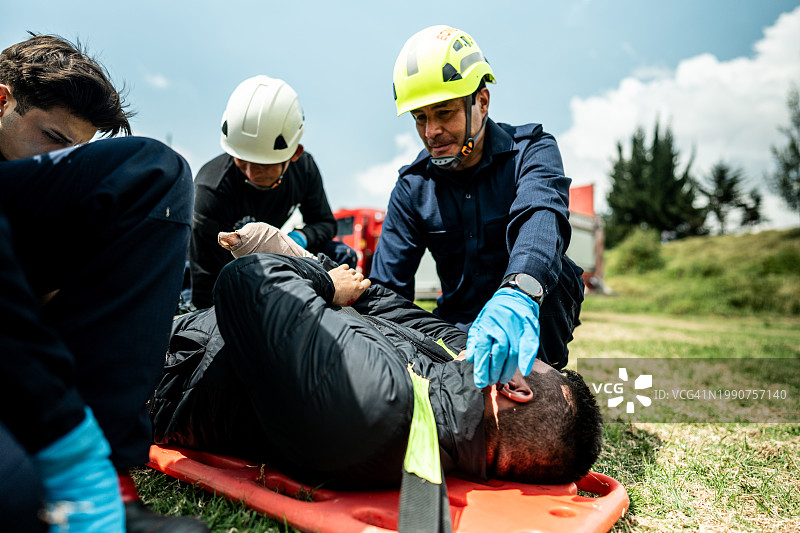 急救人员将事故伤者抬上担架图片素材