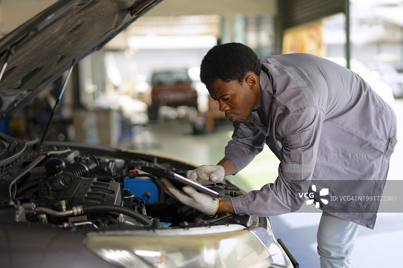 在汽车维修店工作的蓝领工人图片素材