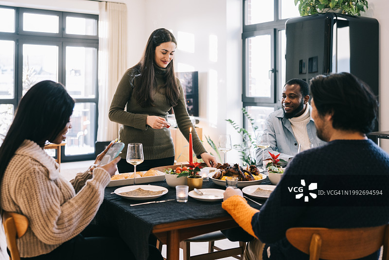 在圣诞晚宴上点燃蜡烛的女人图片素材