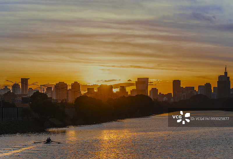 孤独的划船者欣赏着城市壮观的黎明图片素材