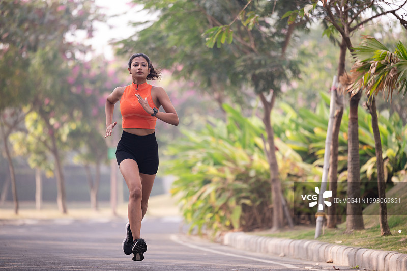 运动女孩在湖边的公园里跑步图片素材