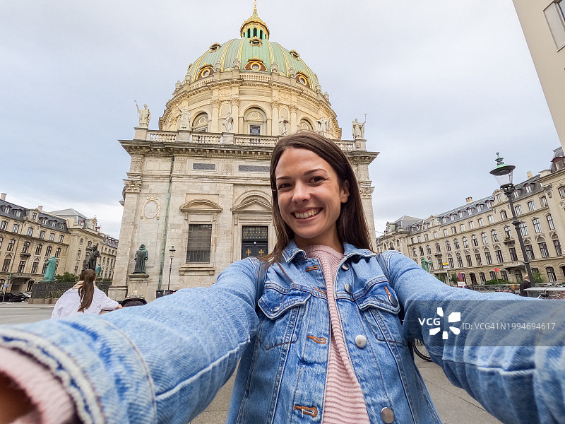 在哥本哈根腓特烈教堂前自拍的年轻女人图片素材