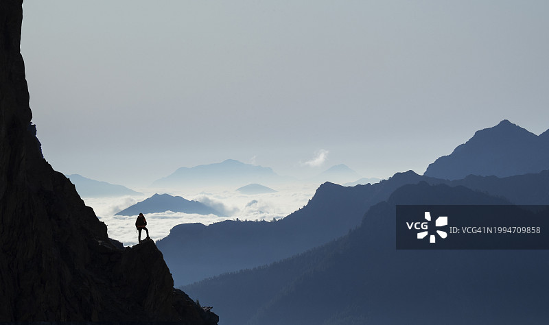 登山者站在岩石上观看山脉图片素材