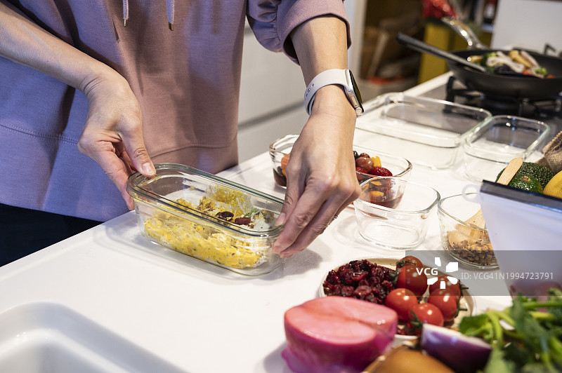 用可重复使用的玻璃容器储存熟食的女人图片素材