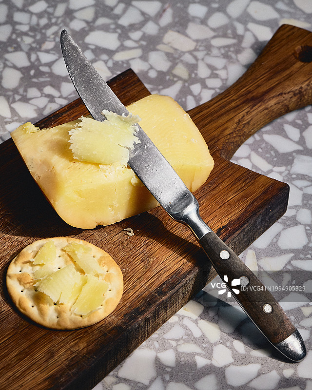 砧板上带刀和饼干的硬奶酪图片素材