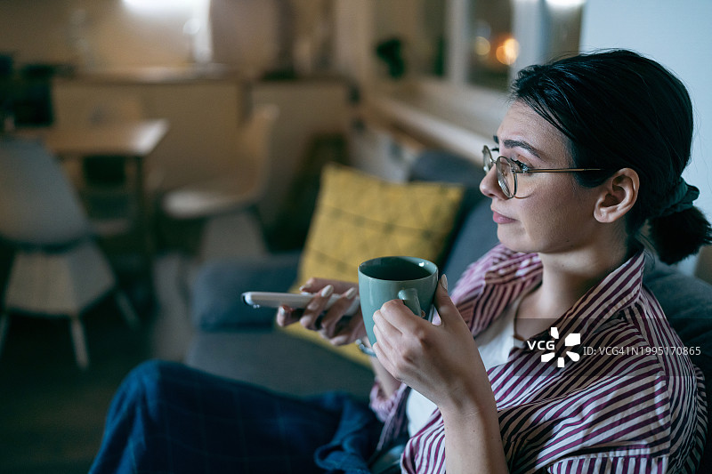 年轻女人在家看电视图片素材