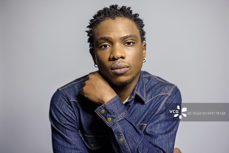 灰色背景上沉思的年轻非洲男人 портрет图片素材