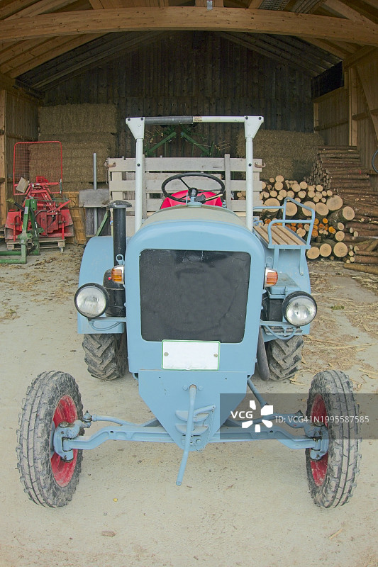 木制干草棚里的老式拖拉机图片素材