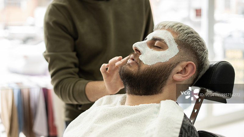在理发店做面膜的年轻男人图片素材