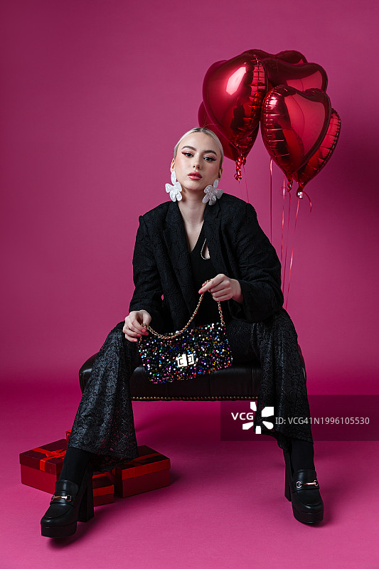 坐在纯色背景前的优雅女子图片素材