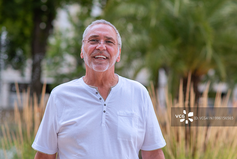 快乐的灰发、胡须、戴眼镜的老年男人图片素材