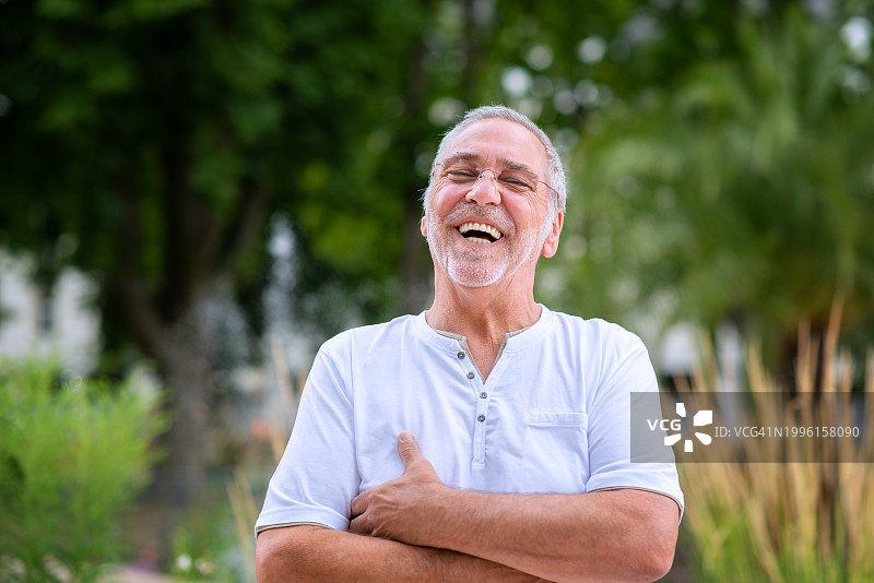 快乐的灰发、胡须、戴眼镜的老年男人图片素材