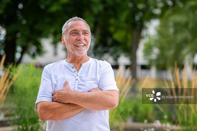 快乐的灰发、胡须、戴眼镜的老年男人图片素材