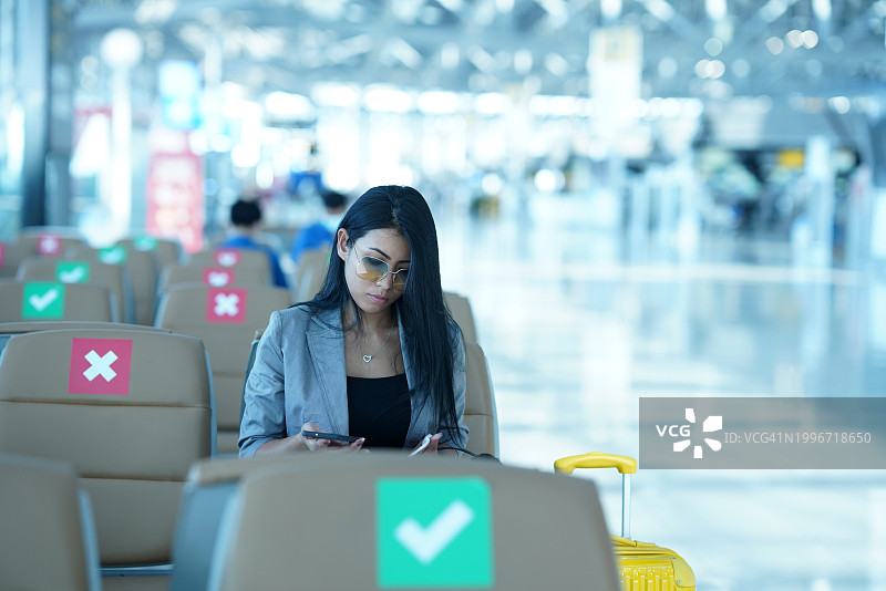 在机场航站楼查看航班信息的女性乘客图片素材