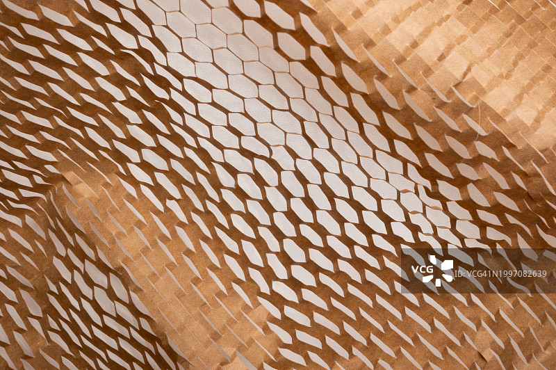 蜂窝纹理纸板背景，带褶皱条纹的包装工艺纸，再生材料利用概念，含留白的设计背景图片素材
