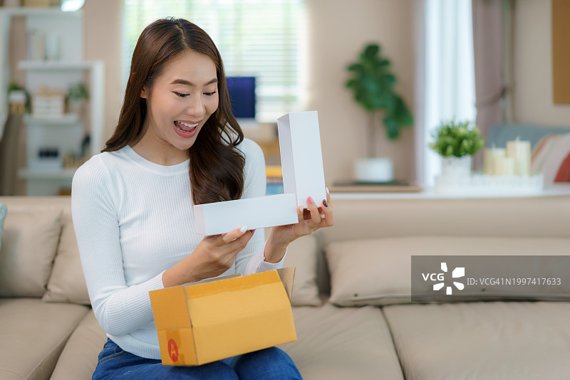 在家打开包裹的亚洲女性图片素材