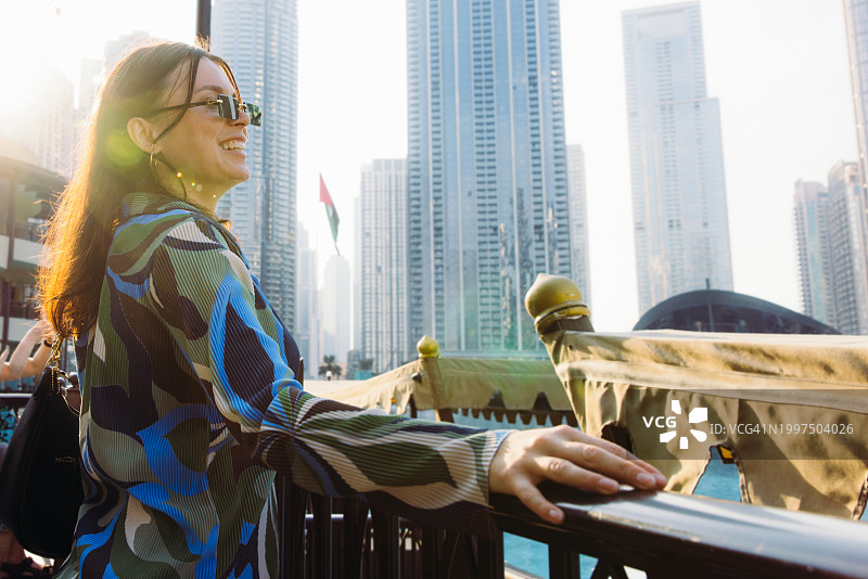 欣赏迪拜市中心摩天大楼壮丽日落的女人图片素材