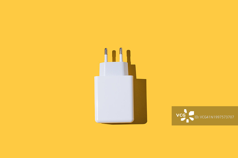 USB和USB-C适配器插头连接到电灯，白色，黄色背景。充电器、灯、适配器、智能手机和设备概念图片素材