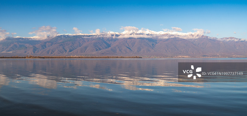 平静湖面上的山脉倒影全景图片素材