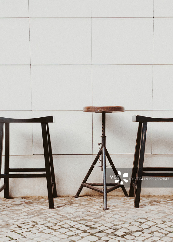 咖啡馆外墙边的三张阁楼式凳子图片素材