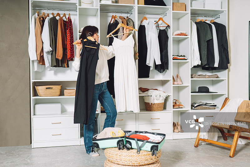 女人在更衣室里收拾行李箱准备旅行图片素材