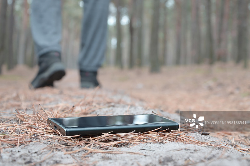 在森林中使用手机的人的下半身视角图片素材