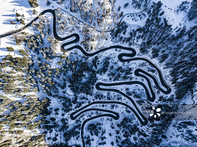 冬季瑞士布雷加利亚森林中蜿蜒道路航拍图片素材