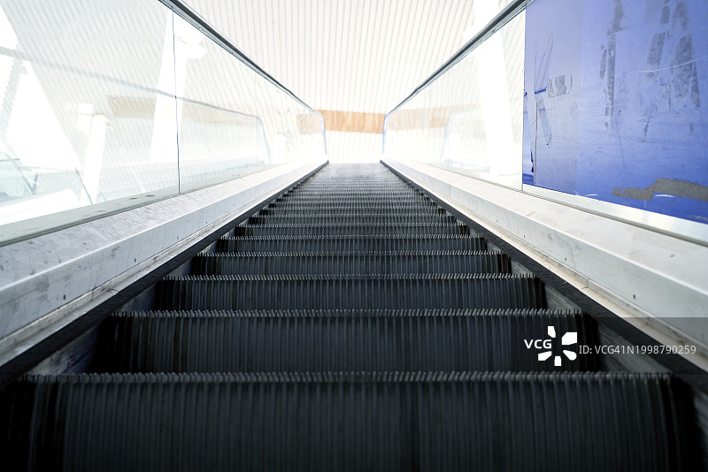 城市购物中心空旷内部的自动扶梯仰视图片素材