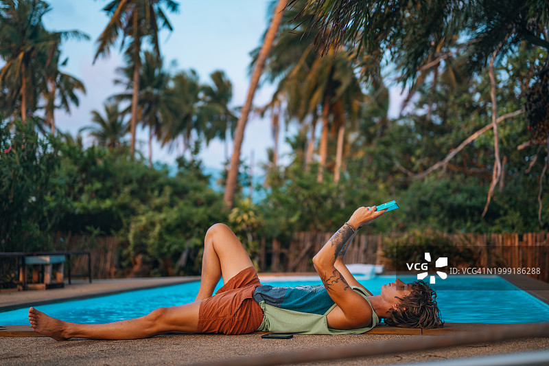 在泳池旁使用科技产品图片素材