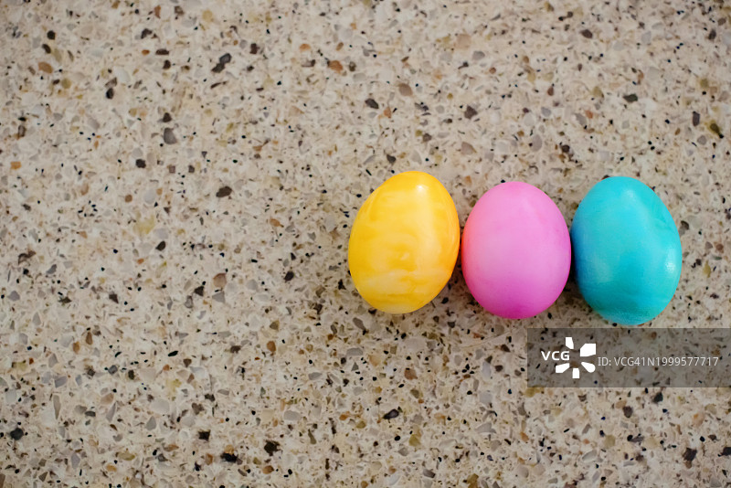 柜台上黄色、粉色和蓝色复活节彩蛋图片素材
