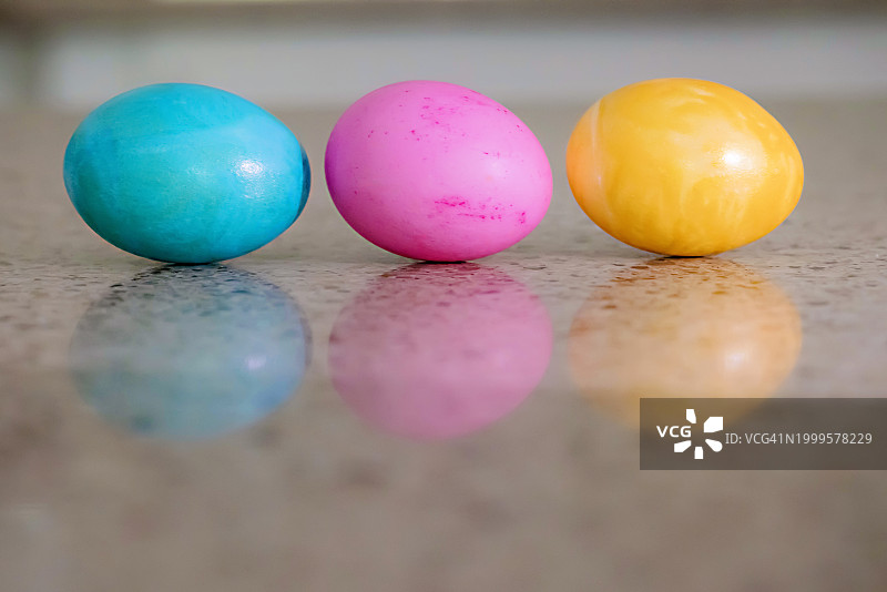 柜台上黄色、粉色和蓝色复活节彩蛋图片素材