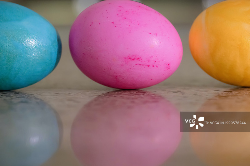 柜台上黄色、粉色和蓝色复活节彩蛋图片素材