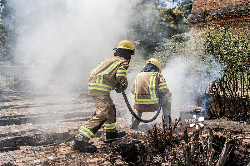 消防员使用软管在户外灭火图片素材
