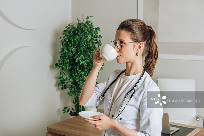 穿白大褂的女医生在办公室喝茶图片素材