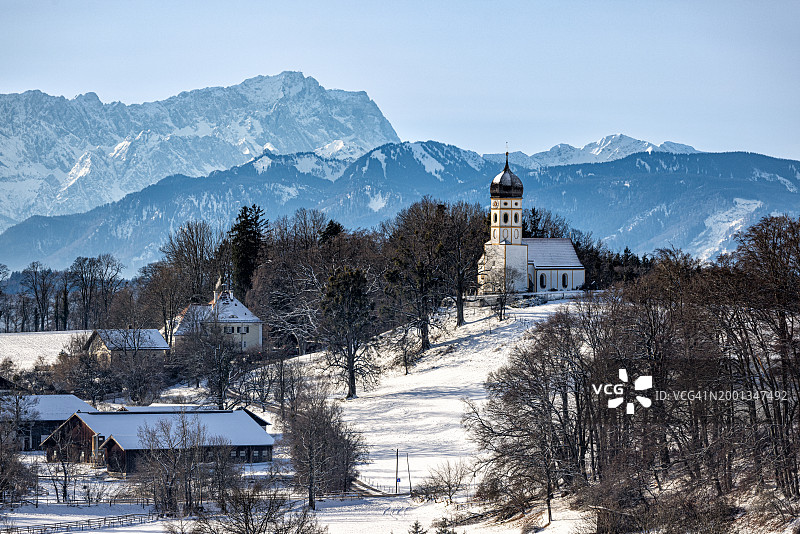 冬季圣约翰·浸信会教堂和楚格峰，德国巴伐利亚州明辛-霍尔茨豪森图片素材