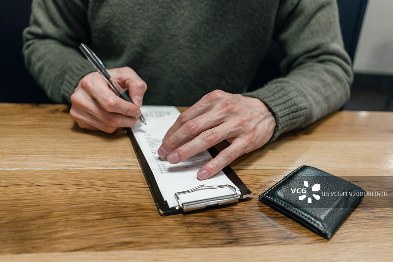 男人在餐厅签署信用卡收据图片素材