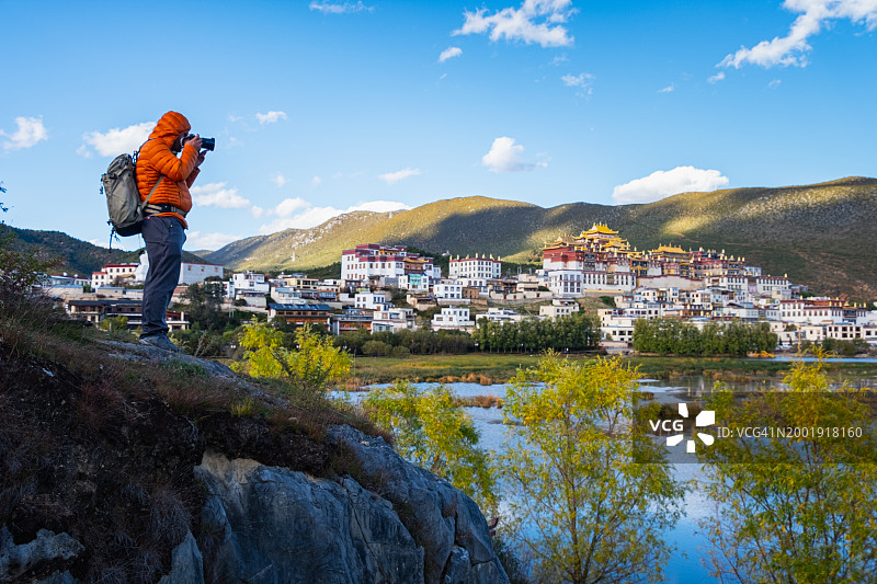 拍摄中国云南香格里拉松赞林寺的年轻旅行者图片素材